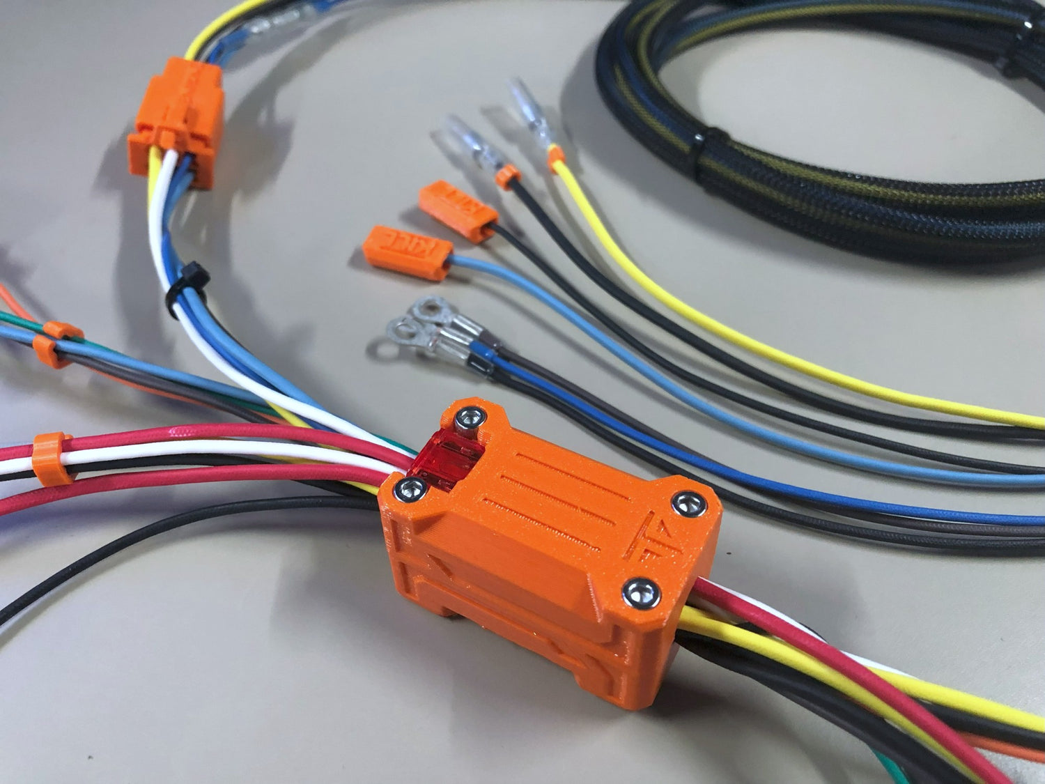 GY6 wiring harness with orange connectors and multicolored wires on a gray background